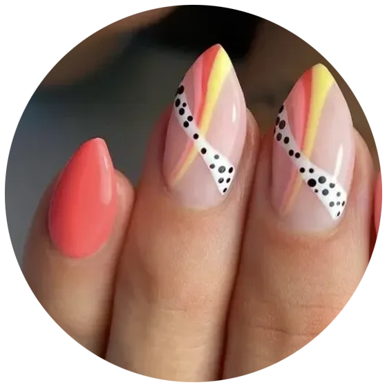 A hand with nail art: two nails are painted coral, while three feature diagonal stripes of yellow, pink, and white, with black dots on the white stripes. The design has a modern and colorful look.